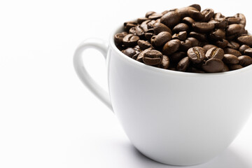 Image of white cup full of coffee beans on white background