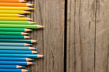 Composition of colorful crayons on wooden background - obrazy, fototapety, plakaty