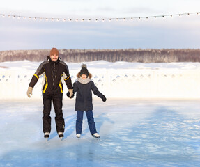 DAD AND DAUGHTER SKATE IN WINTER