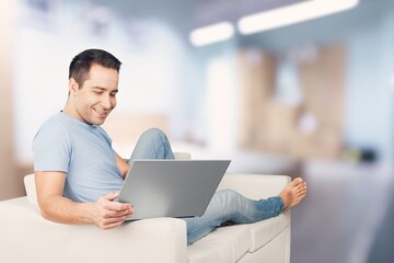 Enjoying Weekend. Handsome Man Sitting Leaning On Couch At Home, Browsing Internet Or Messaging With Friends
