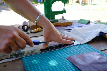 craftswoman working the leather with her hands in a small artisan workshop.