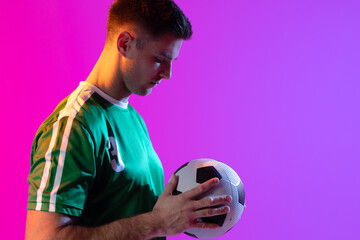 Caucasian male soccer player with football over neon pink lighting © vectorfusionart