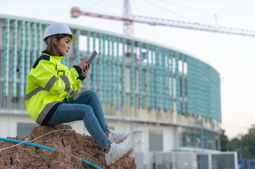 Fototapeta premium Asian engineer working at site of a large building project,Thailand people,Work overtime at construction site