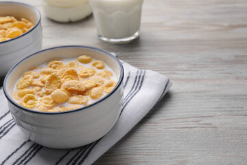 Tasty cornflakes with milk served on wooden table, space for text