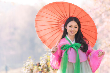 Korean girl wearing a hanbok wearing Pink umbrella. Beautiful Female wearing traditional Korean hanbok in Old town Seoul, Korea.