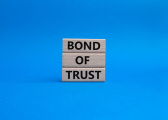 Bond of trust symbol. Wooden blocks with words Bond of trust. Beautiful blue background. Business and Bond of trust concept. Copy space.