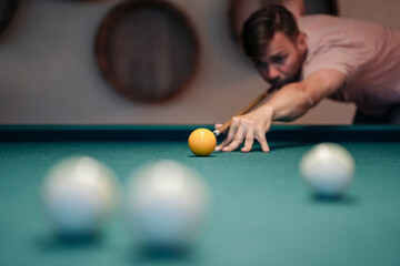 Young man playing billiard indoors. Spending free time on gambling.