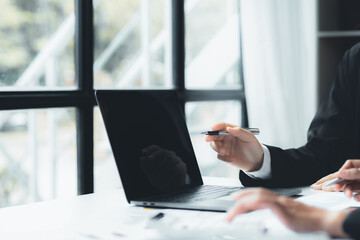 Businesswomen are opening up their laptop's financial information for business partnerships, they are planning to manage their finances and solve common problems. Concept of business administration.