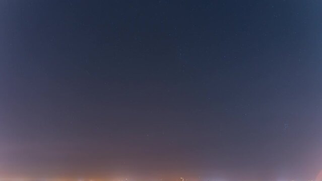 Clear starry sky, satellites and planes fly, stars fall. The sun is emerging from behind the mountains. Time laps