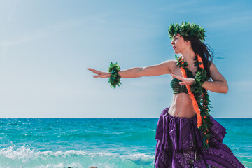 Hula dancer on the beach. Woman in bikini dancing Hawaiian typical of Tahiti. Tropical lady at beach with flower crown on her head and neck. Ready to party. Exotic girl in swimwear. - obrazy, fototapety, plakaty