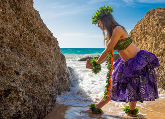 Hula dancer on the beach. Woman in bikini dancing Hawaiian typical of Tahiti. Tropical lady at beach with flower crown on her head and neck. Ready to party. Exotic girl in swimwear.