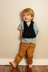 Laughing young boy with broken hand in cast after accident - obrazy, fototapety, plakaty