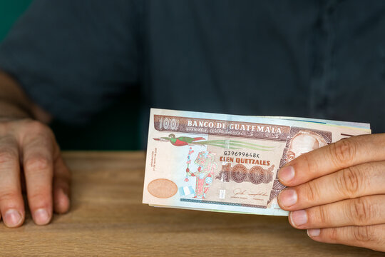 Guatemala currency, A man in a shirt holds money in his hands, financial settlements, Creative business concept, 100 quetzales banknotes