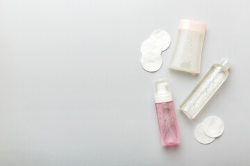 Micellar cleansing water and discs to remove cosmetics and cleanse the skin on colored background. Copy space top view