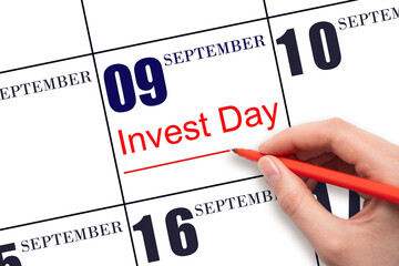 Hand drawing red line and writing the text Invest Day on calendar date September 9. Business and...