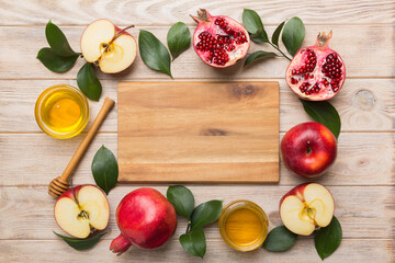 Rosh hashanah, jewish holiday, concept: honey, apple and pomegranate with cutting board, close up