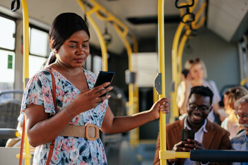 African American woman texting in shuttle bus