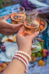 A woman and a man drink wine in a lavender field. Selective focus.