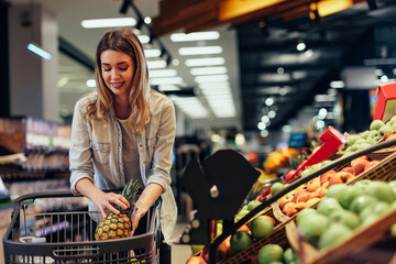Young woman with the cart shopping in supermarket