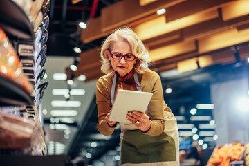 Saleswoman in apron working at supermarket