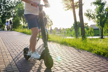 Young man on a modern scooter in the park on a sunny day. Ecological transport © Andrii