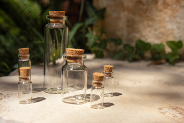 Set of empty glass miniature bottles on natural background. Modern apothecary concept