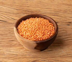 Orange lentil in a bowl over wooden table