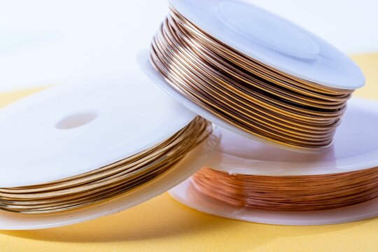 Colored wire for making jewelry from natural stones and natural materials. Wire on white plastic coi