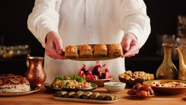 Turkish traditional food, sweet dish, Baklava close-up. Arabian cuisine, treats. Middle eastern national sugar dessert snack. Dolma, hummus, nuts and tabbouleh on table.