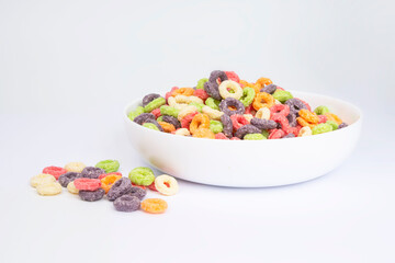 Delicious and nutritious fruit cereal loops multicolored flavorful on white background, healthy and funny addition to kids breakfast