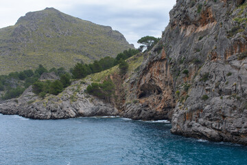Fototapeta na wymiar Turquoise sea water and coastal cliffs in Sa Calobra, Mallorca, Spain