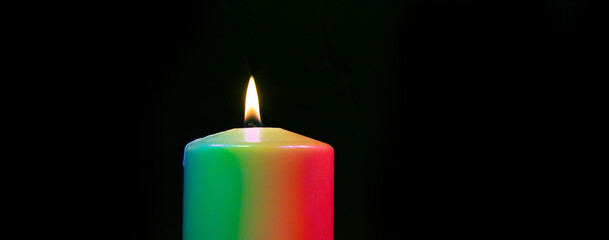 Rainbow colored candle burning
