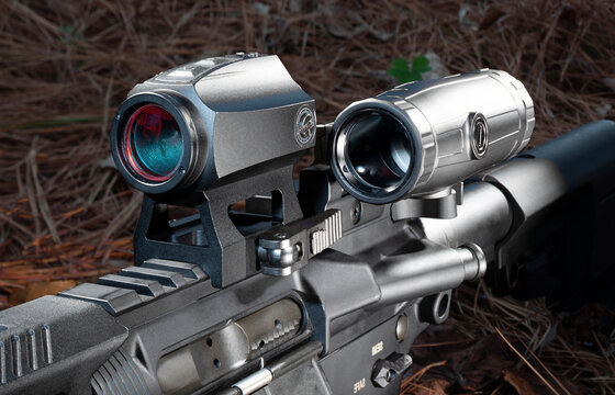 Magnifier to the side of a red dot scope on a modern sporting rifle