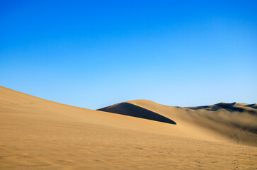 Fototapeta na wymiar Sand desert with dune and blue sky - dunas de Ica, Huacachina, Peru
