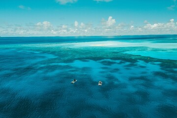 Aerial view of people in small boats swimming in the crystal clear water