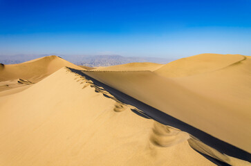 Fototapeta na wymiar footprints on edge of sand dunes in the desert - dunas de Ica, Peru