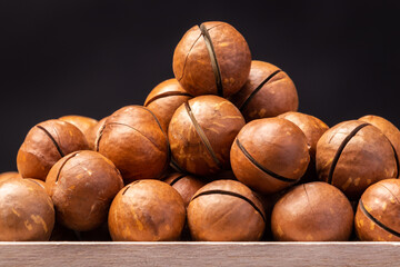 a pile of macadamia nuts on a wooden table close-up
