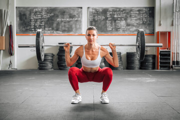 Sportswoman doing barbell back squat