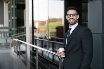 Fototapeta premium man in suit drinking coffee at business street