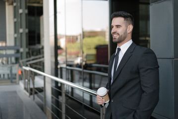 man in suit drinking coffee at business street