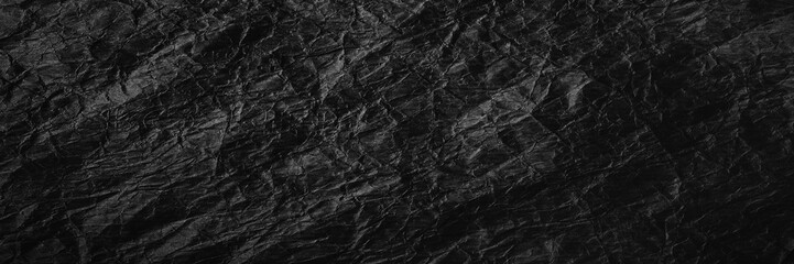 Crumpled black kraft paper. Texture of crumpled black recycled paper. The concept of recycling and reuse of paper and garbage.