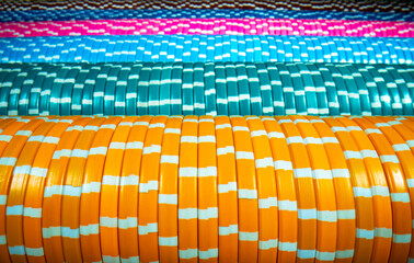 Horizontal rows of colored casino chips. Set of yellow, blue and pink gambling chips. The concept of a casino, playing poker, roulette or craps. Bet, money, win. Extra close up.