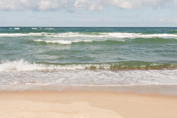 Fototapeta na wymiar Baltic Sea - view from the beach to the sea with waves on a sunny day