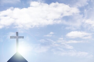 Silhouette of Christian cross over clouds against sky in the background. Easter religion faith...