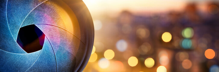 Сamera lens on the background of the fiery city lights. Concept on the topic of news, media,...