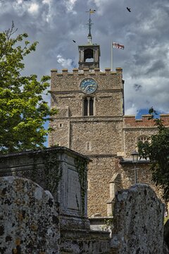 Vertical shot of Baptist church Saint John with clock under cloudy sky