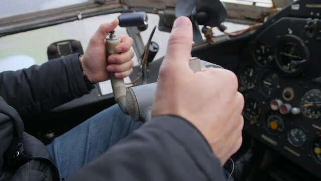 Close-up. Male hands of the pilot take the steering wheel of the plane. Vintage style. The old historical cabin AN-2.