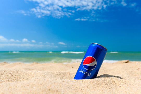 Anapa - Russia, July 2022: A cold can of Pepsi soft drink on the seashore against the background of the sky and waves. Selective focus on the logo.