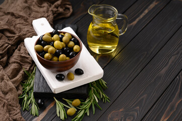 Black and green olives on a dark wooden rustic background.