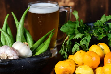 pequi fruit typical Brazilian food, okra spices, salad and melted cheese au gratin with choop mug on blurred background